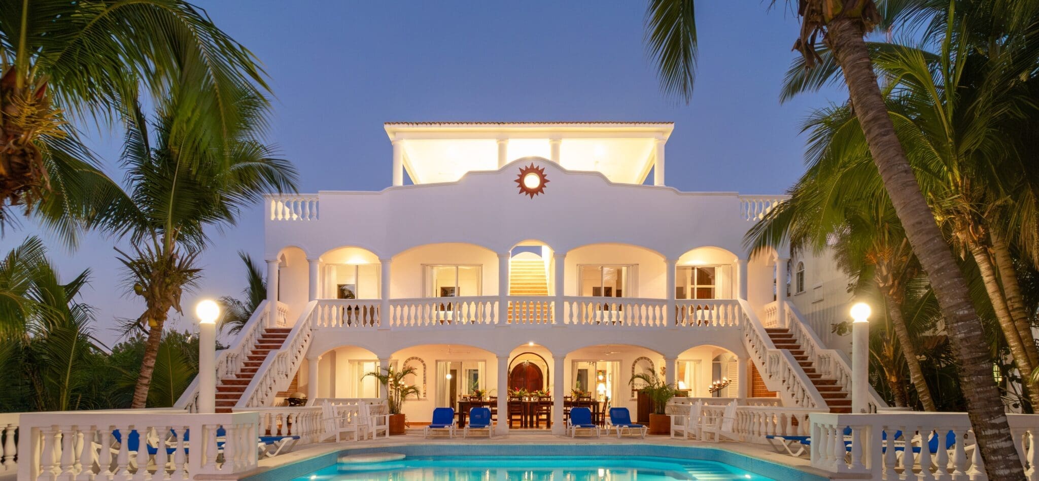 Luxurious villa with pool and palm trees.